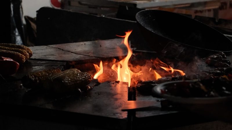 A person cooking food on a grill in a kitchen